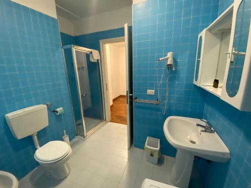 a blue bathroom with a toilet and a sink at Residence Le Terrazze in Trieste
