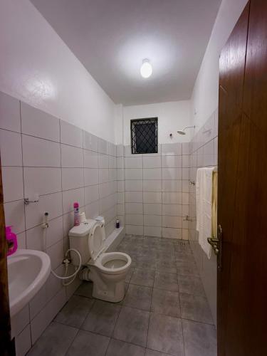 a bathroom with a toilet and a tub and a sink at Nyali 3 Bedroom Apartment Skyview in Mombasa