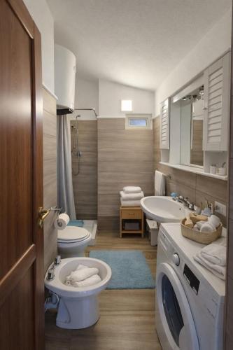 a bathroom with two toilets and a sink and a washing machine at Cala Greca Case Vacanze in Capo Rizzuto