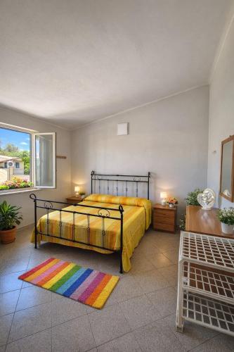 a bedroom with a bed and a rainbow rug at Cala Greca Case Vacanze in Capo Rizzuto