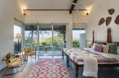 a bedroom with a large bed and a balcony at SaffronStays Vinayalam in Mahabaleshwar