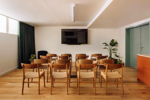 a room with a table and chairs and a tv at Locke de Santa Joana in Lisbon