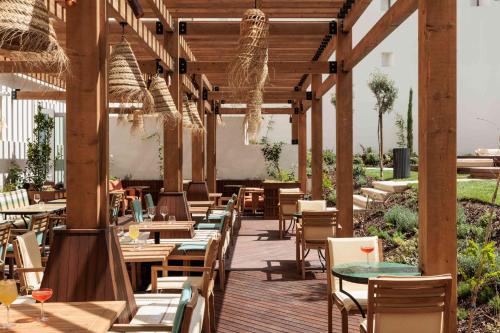 a restaurant with wooden tables and chairs and ailion at Locke de Santa Joana in Lisbon