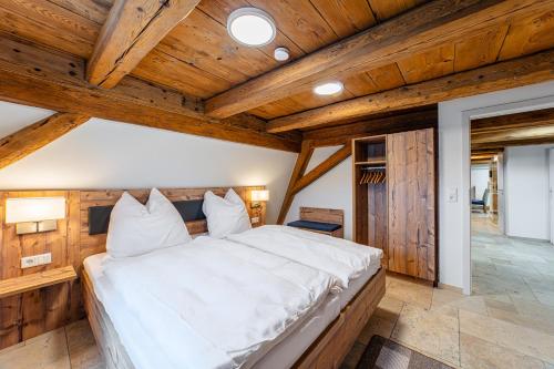a large bed in a room with wooden ceilings at Gästehaus Hopfenperle in Spalt