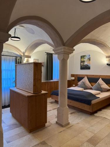 a bedroom with a bed and a tv and columns at Privat SPA Premium Suite 117 qm in Wehlenberg