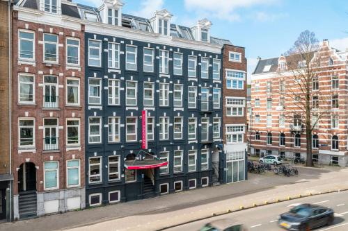 a black building with white windows on a city street at Leonardo Hotel Amsterdam Leidse Square in Amsterdam