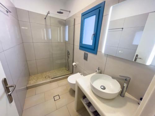 a bathroom with a sink and a toilet and a window at Amorgona Apartments in Katapola
