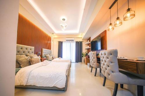 a bedroom with a bed and a desk and chairs at Alpine Villas at Crosswinds Tagaytay Casa de Vela in Tagaytay