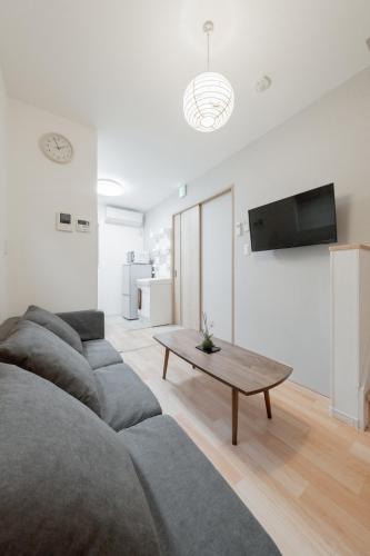 a living room with a couch and a coffee table at 九条駅から3分 難波直通6分 usj11分 一戸建民宿 in Osaka