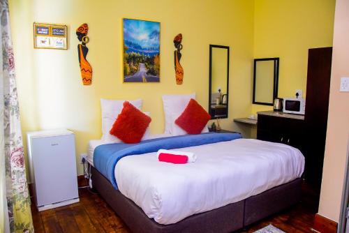 a bedroom with a large bed with red pillows at Umzimkulu Hotel in Umzimkulu