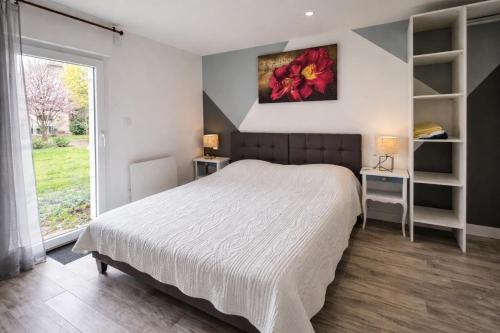 a bedroom with a large bed and a window at Domaine des Moizons, Le Laurier in Villebernier