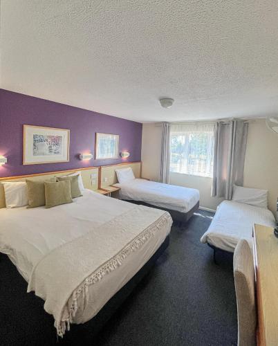 a hotel room with two beds and a window at Travel Plaza Hotel in Desborough