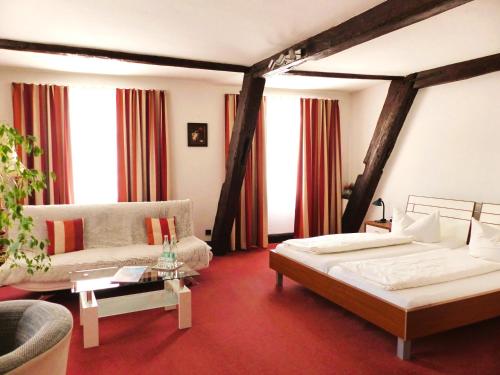 a bedroom with a bed and a couch and windows at Hotel Zum Schwarzen Walfisch in Bad Säckingen