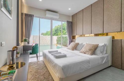 a bedroom with a large bed and a large window at 63 Jomtien Beach villa วิลล่าใกล้หาดจอมเทียน 這棟別墅距離海灘不遠 in Jomtien Beach