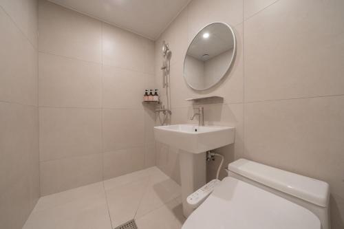 a bathroom with a toilet and a sink and a mirror at Anook Hotel Daejeon Daeheung in Daejeon