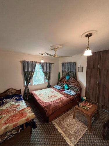 a bedroom with two beds and a window at Karnai Residency in Srinagar