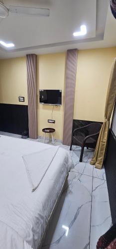 a large bed in a room with a tv at Hotel Roshan in Ujjain