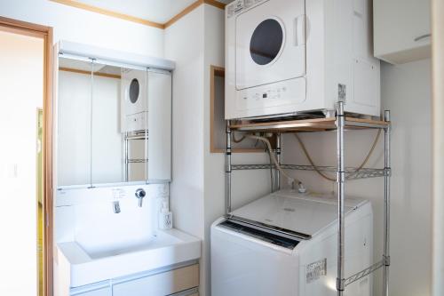 a white laundry room with a washer and dryer at NIYS apartments 04 type in Tokyo