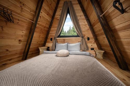 ジャブリャクにあるPeaksView Chaletsの大きな窓のある丸太小屋の寝室