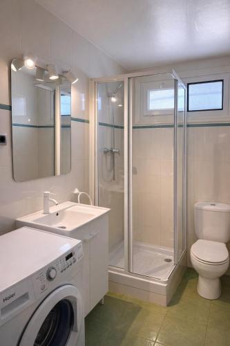 a bathroom with a shower toilet and a washing machine at Les cases del vent II in Calafat