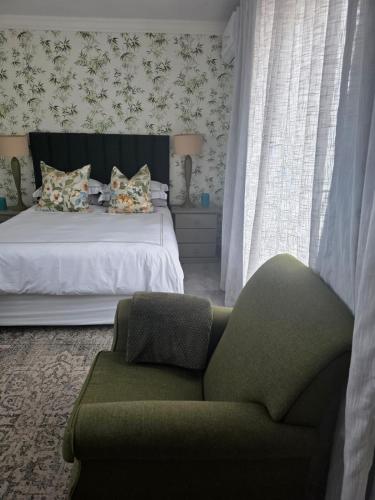 a bedroom with a bed and a green couch at Pennington Splendor Apartment in Pennington
