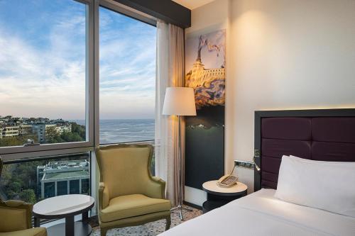 a hotel room with a bed and a chair and a window at DoubleTree By Hilton Istanbul - Moda in Istanbul