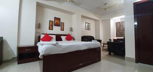 a bedroom with a large bed with red pillows at Hotel Fort in Patna