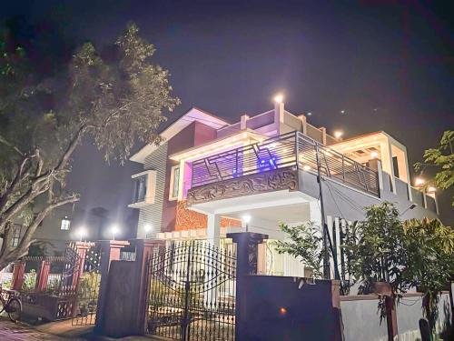 a large white house with a balcony at night at Swapno Chhobi in Bolpur
