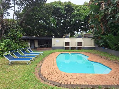 a group of chairs sitting around a swimming pool at Shore Breakers in Shelly Beach