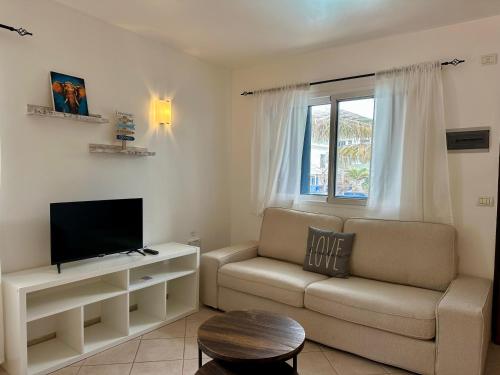 a living room with a couch and a tv at Leme Bedje - By Bobbywashere in Santa Maria