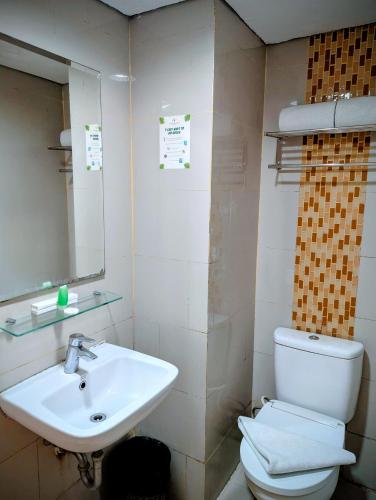 a bathroom with a sink and a toilet and a mirror at Sahid Mutiara Karawaci in Tangerang