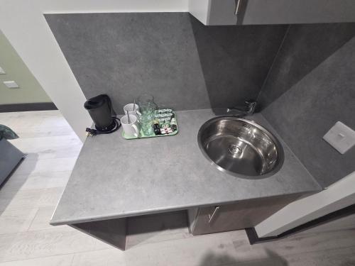 a bathroom counter with a stainless steel sink at 1066 Apart Hotel in Hastings