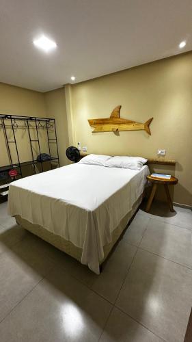 a bedroom with a bed with a wooden airplane hanging on the wall at Chalés Boqueirão beach in Japaratinga