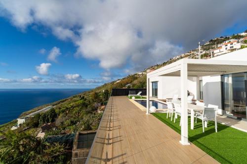 a balcony of a house with a view of the ocean at GuestReady - The Ocean El Cid in Fajã da Ovelha