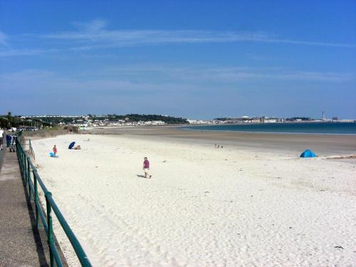 a group of people on a sandy beach at 1 Bed House On The Beach in St Peter