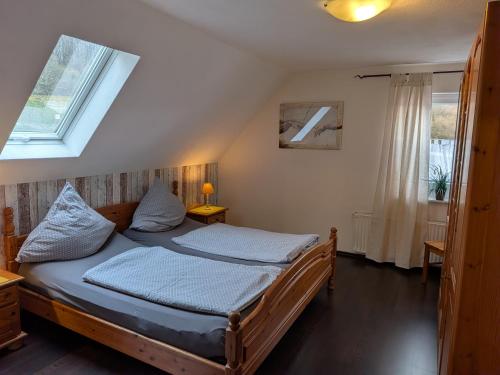 a bedroom with a wooden bed with two pillows at Ferienwohnung Eiernest in Briedeler Heck