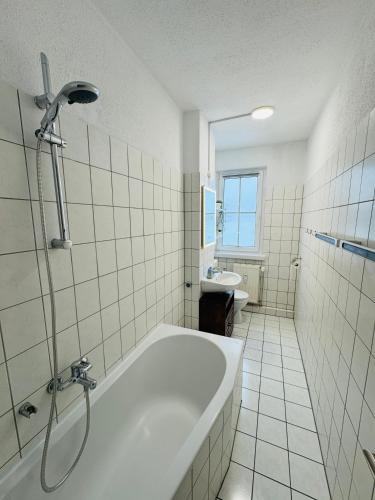 a white bathroom with a tub and a sink at FeWo Einetal 4 im schönen Ostharz in Schielo