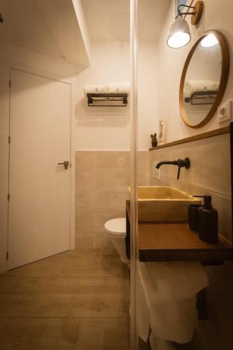 a bathroom with a sink and a toilet and a mirror at The Wave House in Jávea