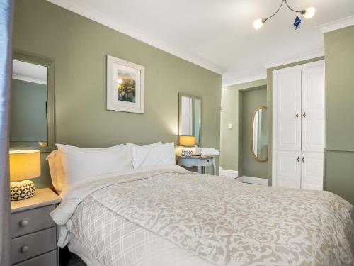 a bedroom with a bed with a white comforter at Errismore House in Clifden