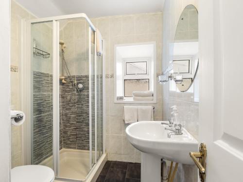 a white bathroom with a sink and a shower at Errismore House in Clifden