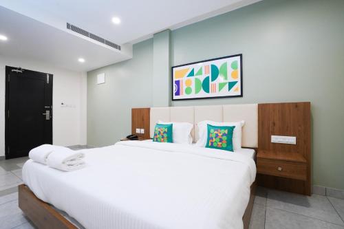 a bedroom with a large white bed in a room at IGNIVA Airport Hotel in Calicut