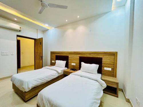 two beds in a hotel room with white sheets at Hotel Silver Bricks in Amritsar