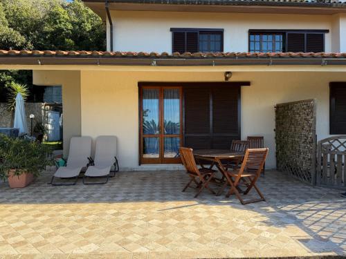 a patio with a table and chairs in front of a house at Casa Alessia , il tuo angolo di pace a Nisporto in Nisporto