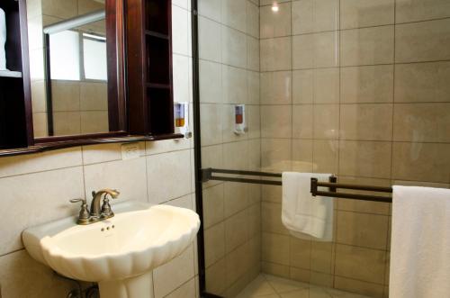 a bathroom with a sink and a shower at Hotel Plaza Real Suites & Apartments San Jose in San José