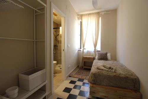 a small bedroom with a bed and a bathroom at Hostal Las Acacias in Málaga