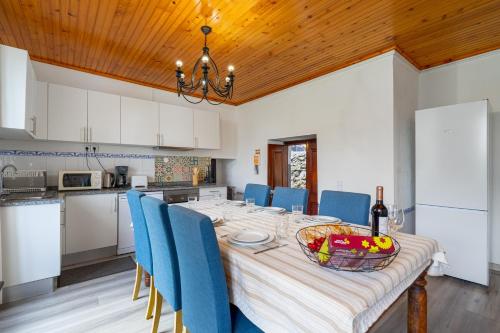a dining room with a table and blue chairs at Gouveia Cottage in Seixal