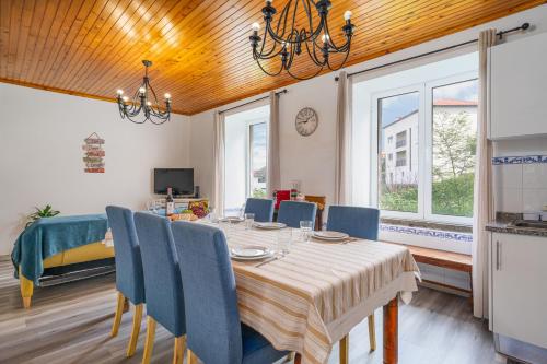a dining room with a table and blue chairs at Gouveia Cottage in Seixal
