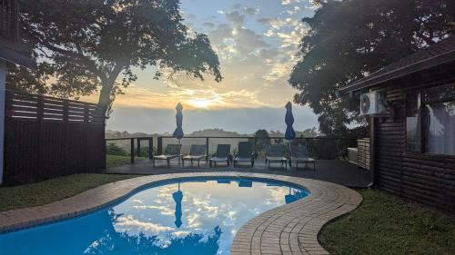 a swimming pool in a yard with two chairs at Ocean View Nature Lodge in St Lucia