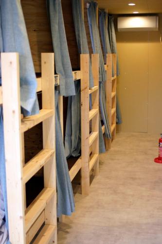 a row of racks in a closet with blue curtains at Guesthouse Sensu in Tokyo