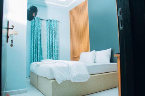 a bedroom with a bed with blue walls at Mbre Hotel and Resorts in Uyo